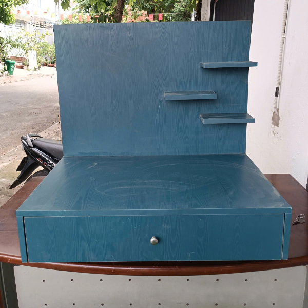 Bàn trang điểm xanh dương có kệ gắn tường và ngăn kéo.