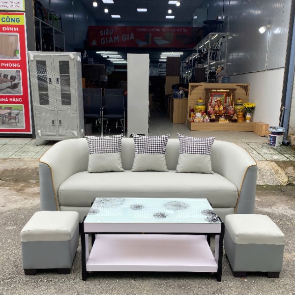Bộ sofa văng da cao cấp màu xám phối màu kèm bàn trà mặt kính và hai đôn đồng bộ.